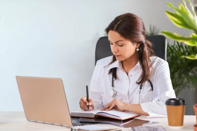 Médica estudando inglês frente ao computador