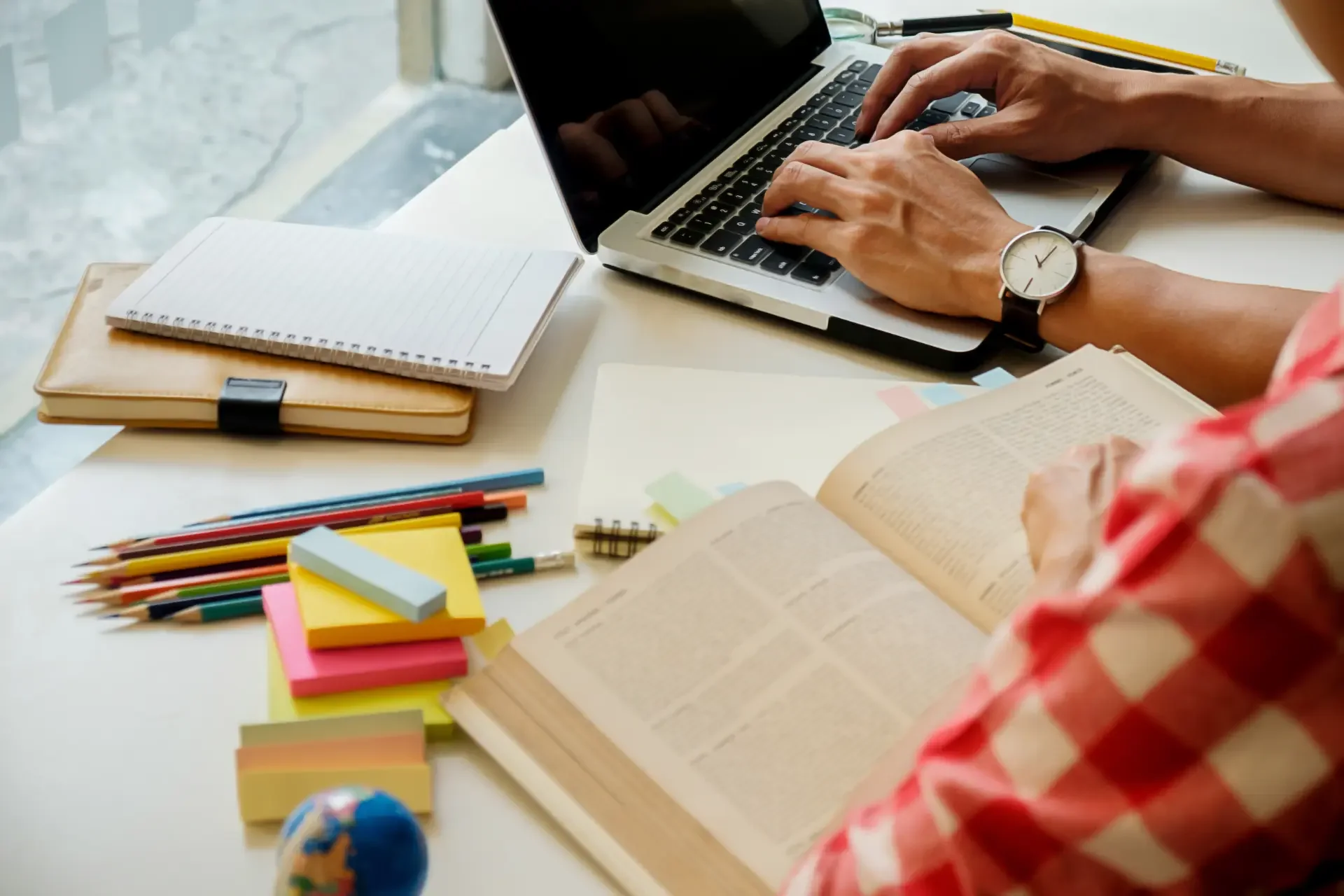 Estudante usando computador e livros com o método de imersão de inglês online