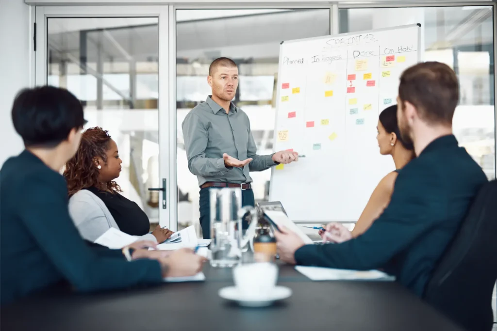 Profissional apresentando ideias em quadro branco durante reunião de negócios