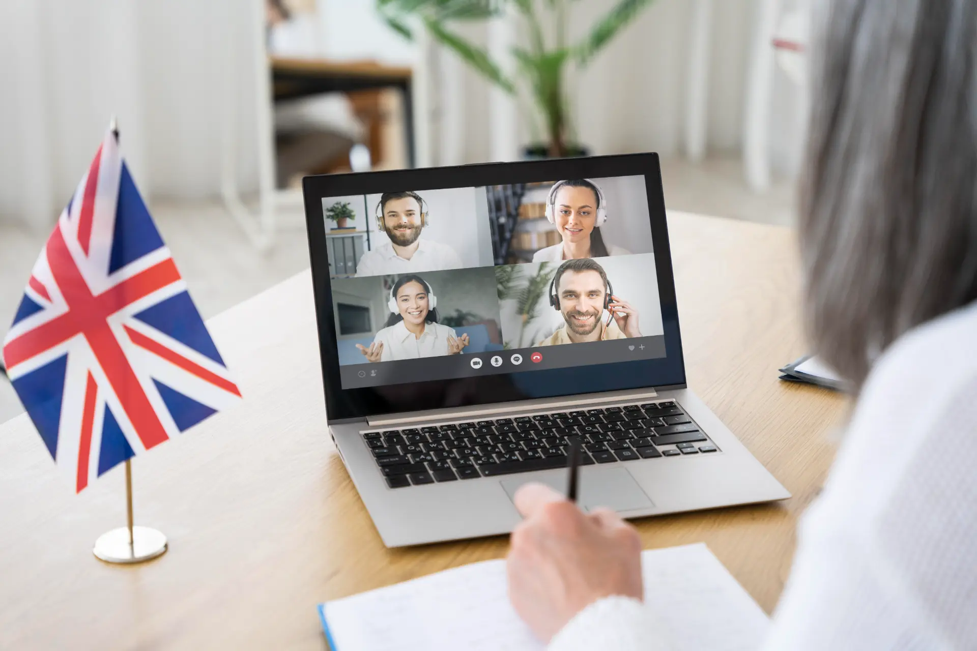 Professora de inglês ensinando alunos em aula online sobre níveis de inglês.