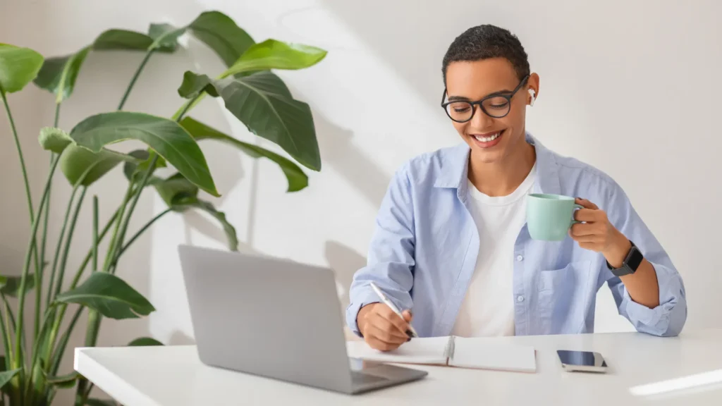 Profissional sorrindo no escritório mantendo o hábito de estudar inglês
